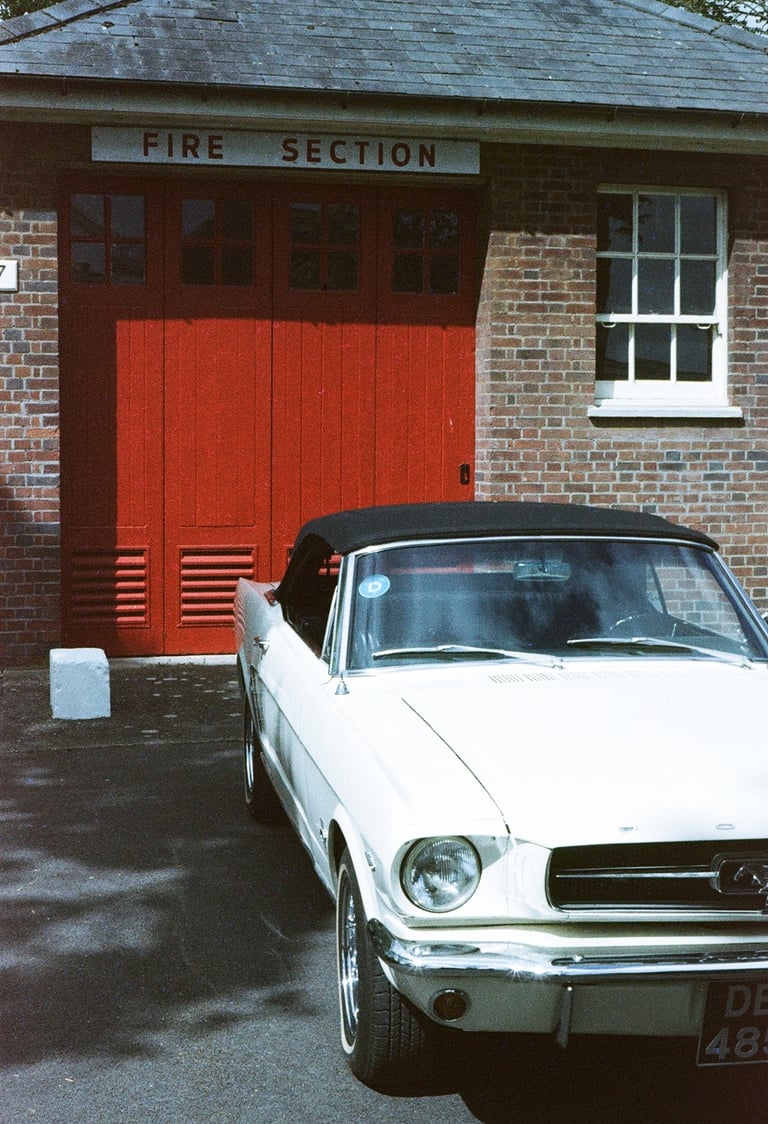 a classic Ford Mustang parked in front of a brick building