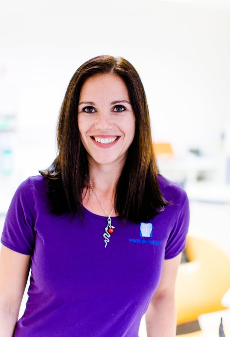 a woman in a purple shirt and a necklace