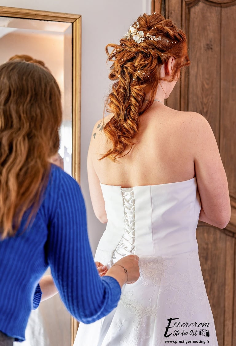 a woman in a wedding dress is looking at her reflection in the mirror