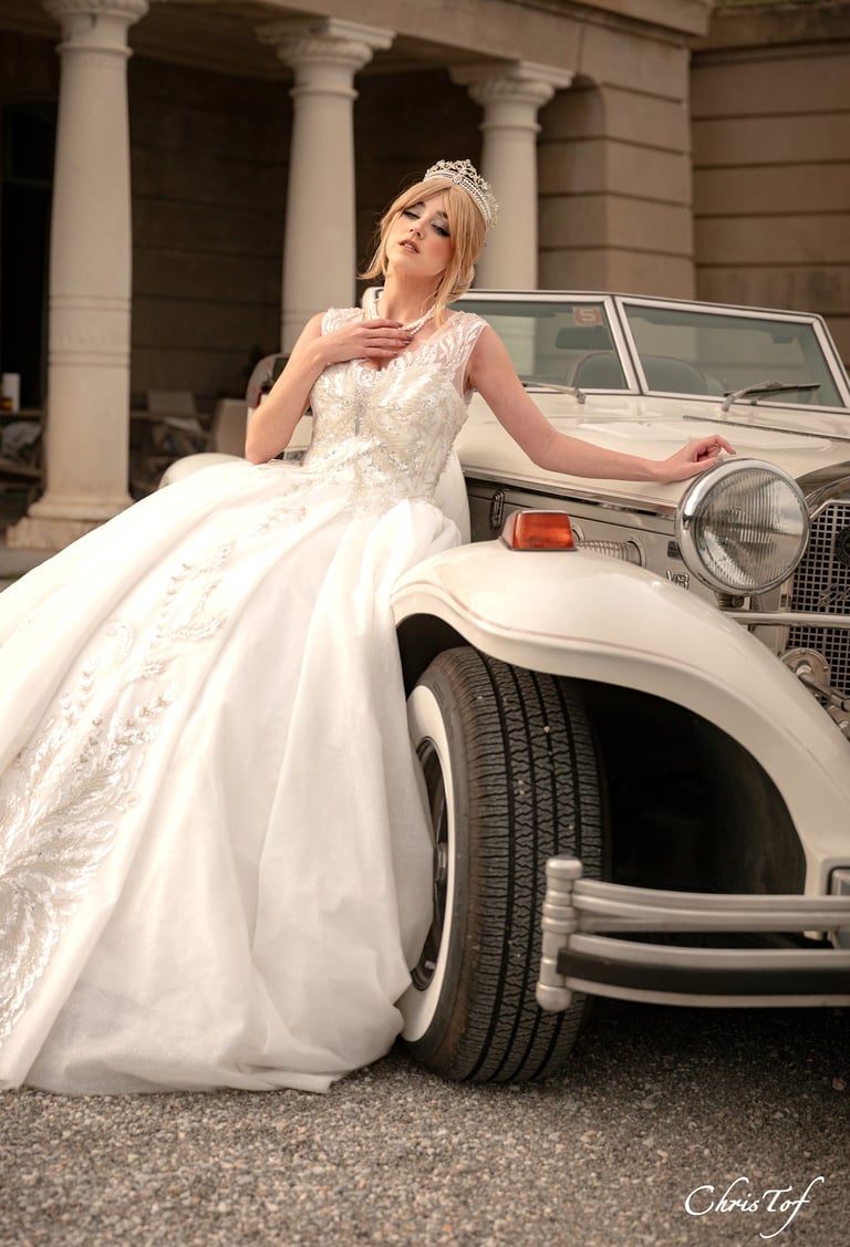 photo d'une mariées en robe de mariée devant une voiture retro au chateau de valmy 66 