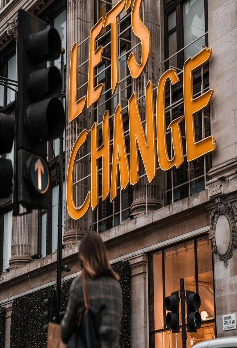 Large sign reading “Let’s Change” on a city building. 