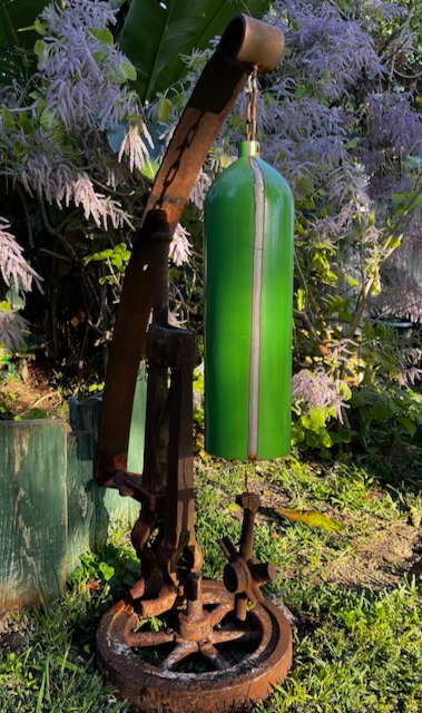 Rustic garden sculpture made from a green cylinder and recycled industrial iron parts.