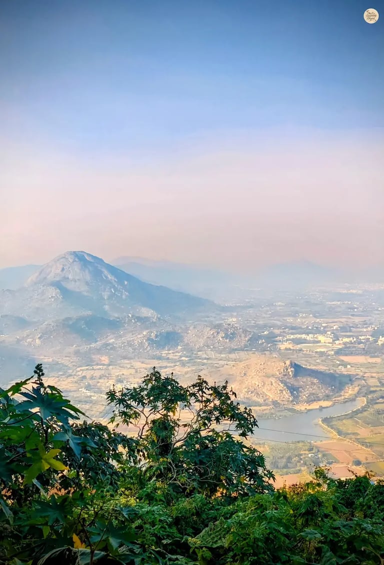 View of Skandagiri peak from the Gandhi Nilaya viewpoint at Nandi Hills, overlooking misty valleys and surrounding hills