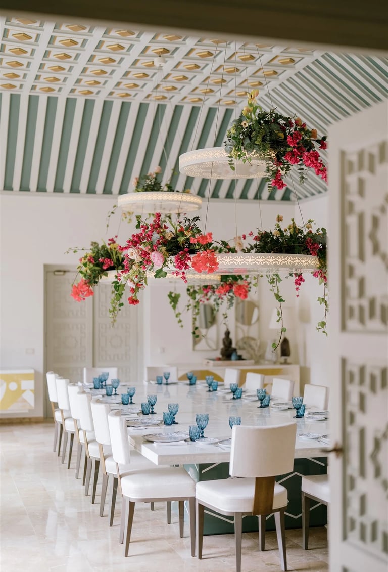 Grand dining room with floral chandeliers and patterned vaulted ceiling