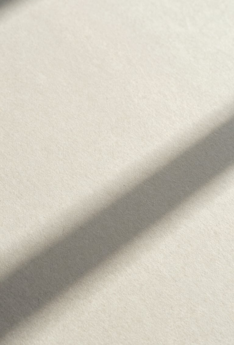 A macro photograph of high-quality off-white paper texture with a single, sharp diagonal shadow. Minimalist composition, natural soft side lighting, professional art archive aesthetic.