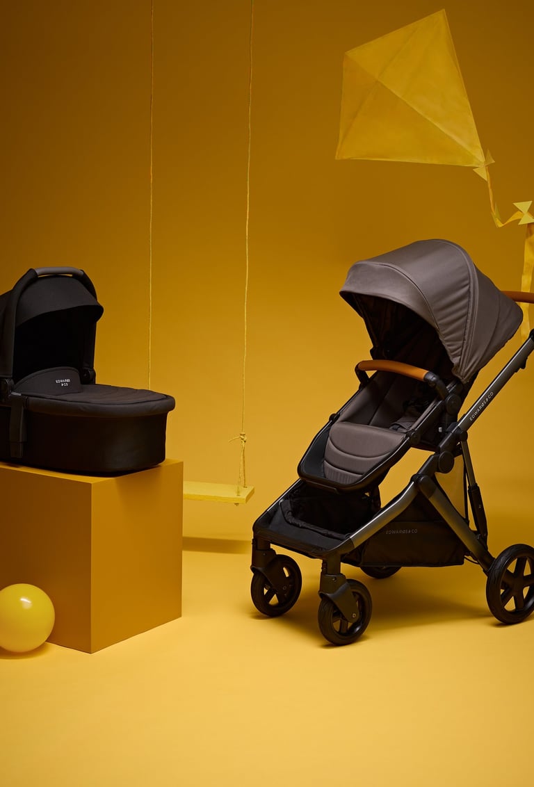 Product campaign photography - a baby stroller and a baby carrier on a yellow background