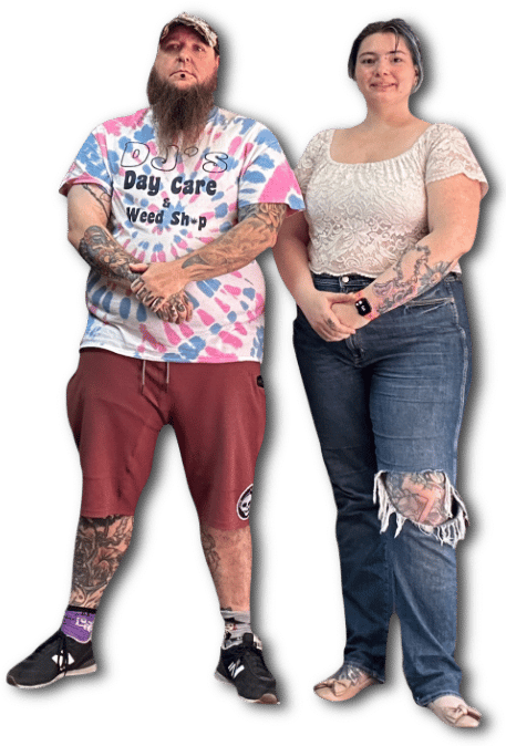 A full-body cutout of Aly Cat & Fecke, alternatively styled professional piercers, stand near each other with crossed arms.