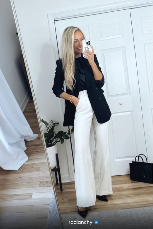 a woman in a black blazer and white pantsuits