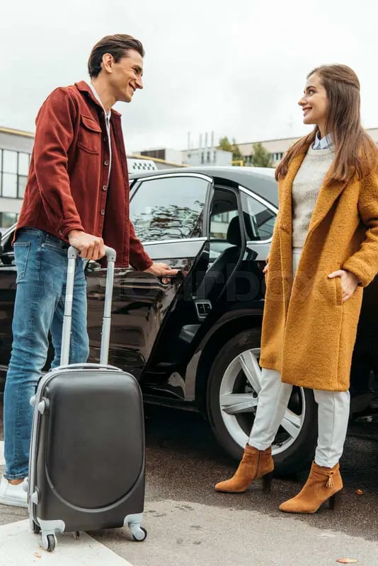 A friendly taxi driver assisting a passenger with luggage