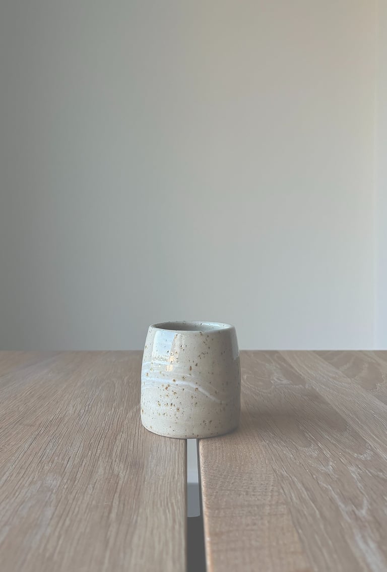 Kleiner, heller Keramikbecher im Japandi-Stil