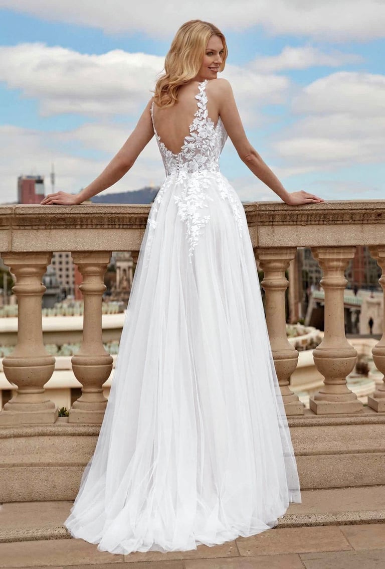 a woman in a white dress standing on a balcony