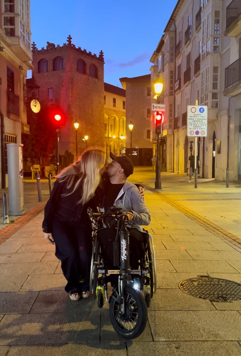 a man and woman kissing on a city street