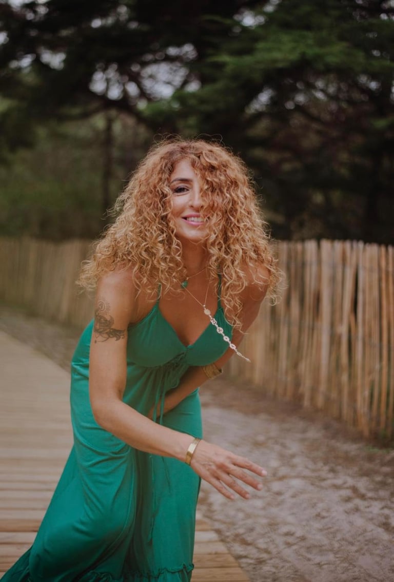 a woman in a green dress and a wooden fence