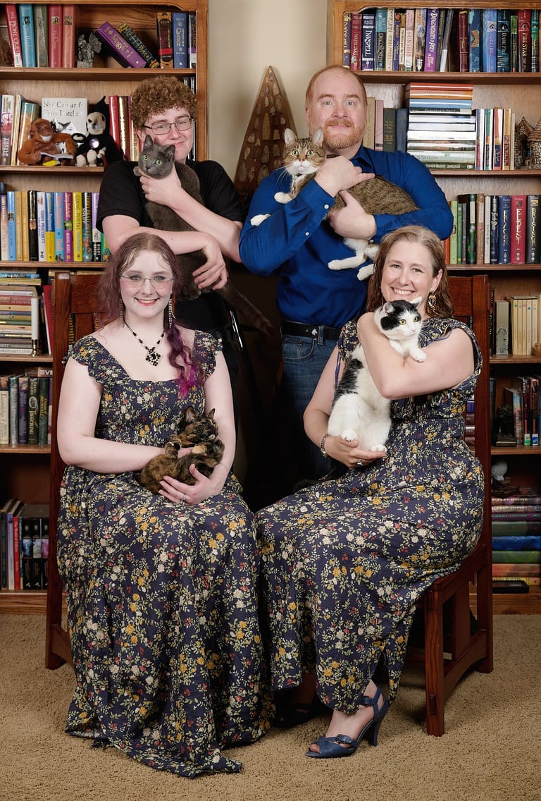 a family portrait of parents and kids with four cats on their arms