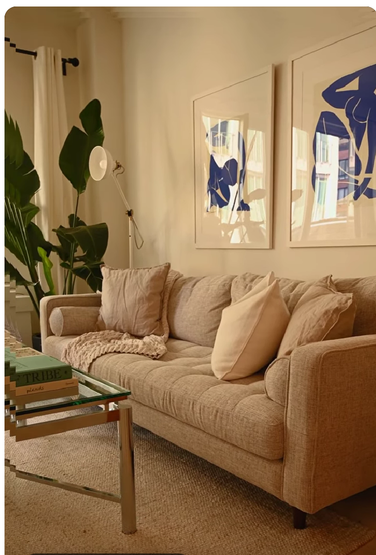Cozy inviting living room with cream upholstery, warm lighting, and soft furnishings