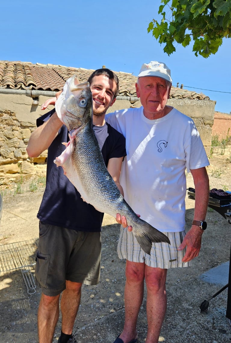 a man holding a fish on a beach