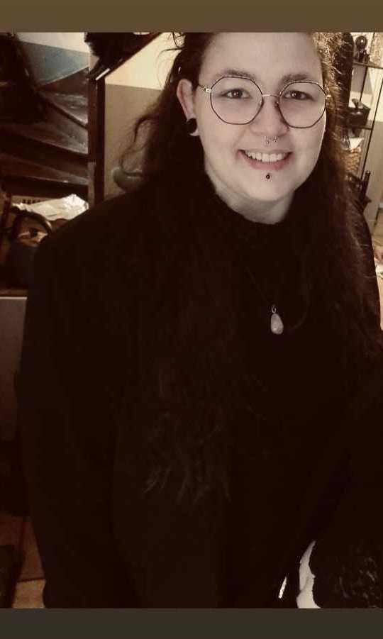 Moi, la créatrice de ce site, de cette marque. Souriante, habillée de noir avec un collier en pierre