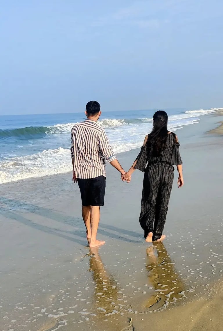 Couple walking hand in hand on Alleppey Beach in Kerala during sunset, enjoying the sea breeze and peaceful shoreline views.