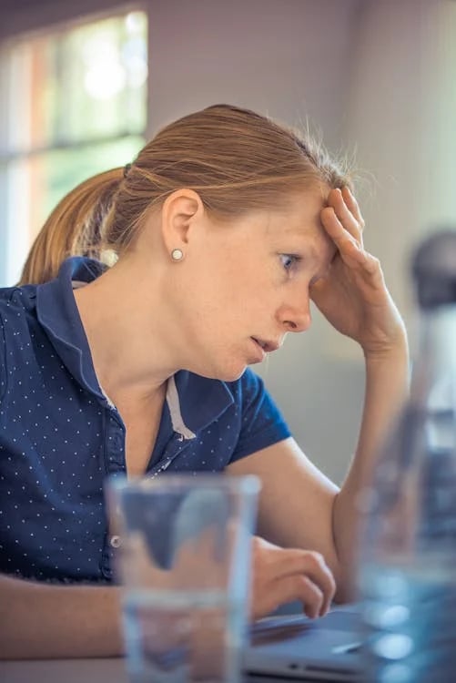 a woman sitting at a table with a laptop computer