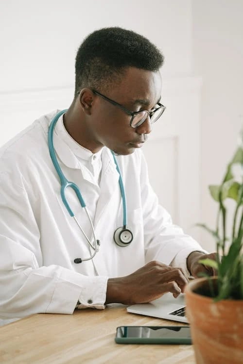 a male doctor in a white lab coat and stethrobe