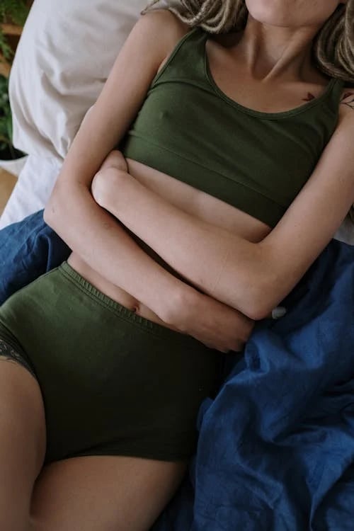 a woman in a green top and a white bottom