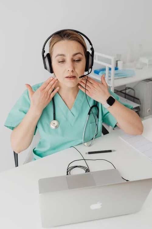 a woman in a green scrub suit and headphones