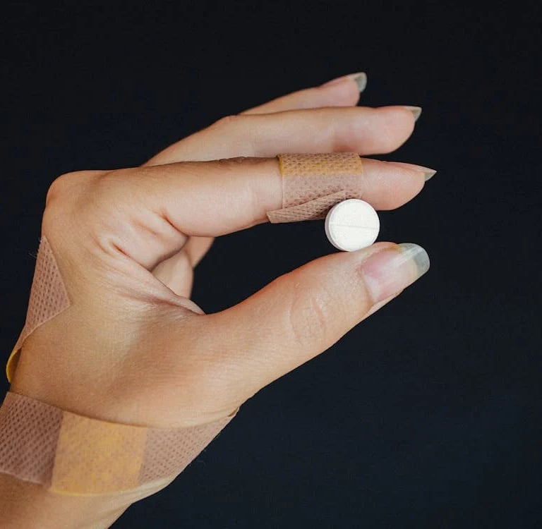 a person's hand holding a bandage and bandage