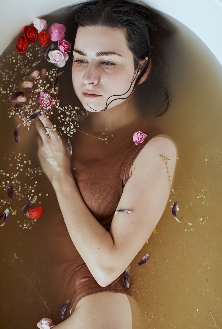 a woman in a brown swimsuit is in a bathtub