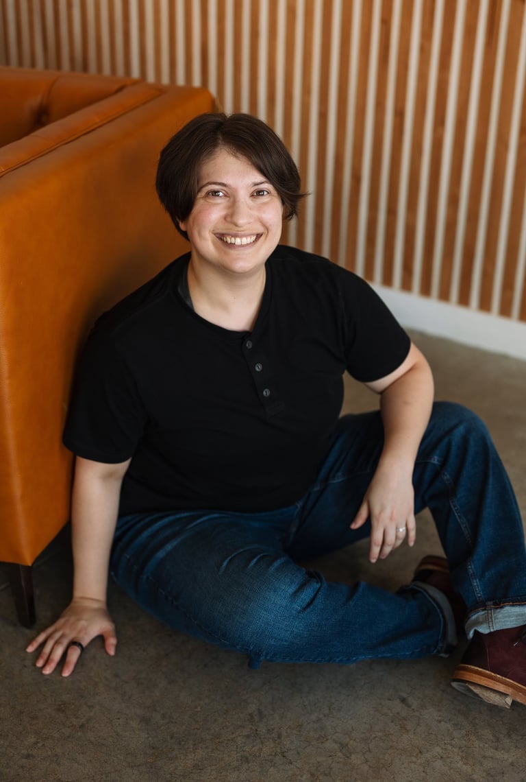 Photo of Rashad McAllister sitting on the floor and smiling at the viewer