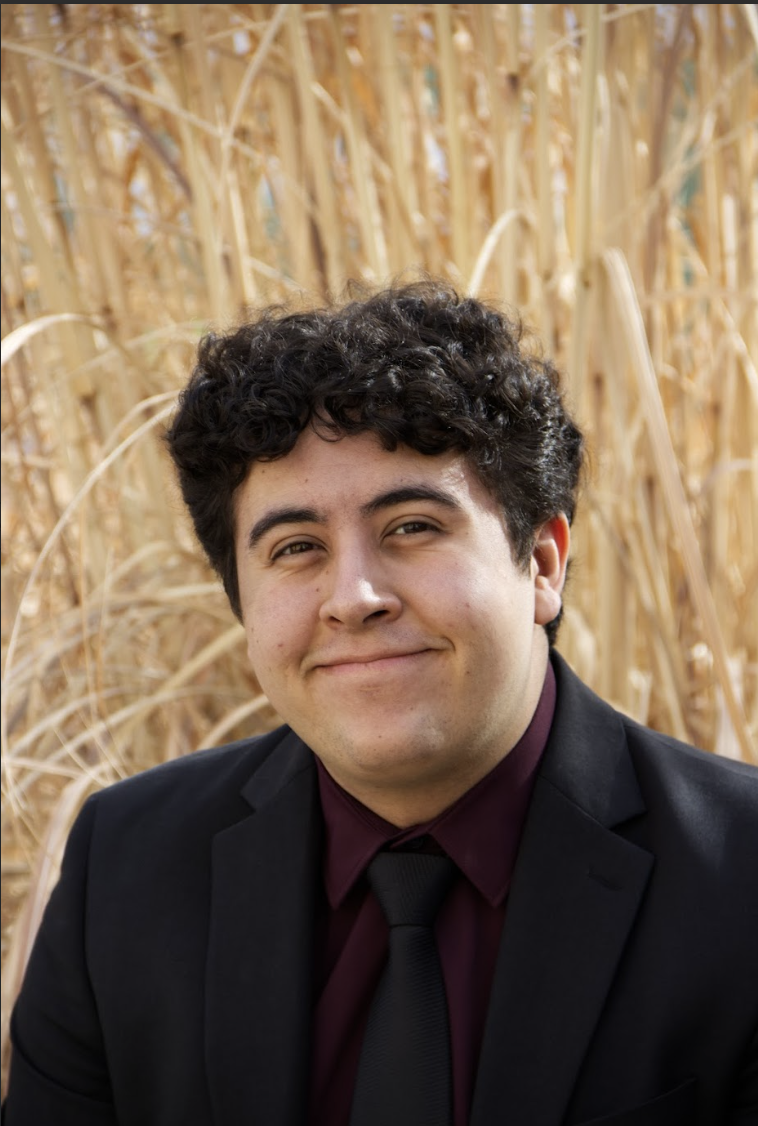 Headshot of Gregg in a black suit.