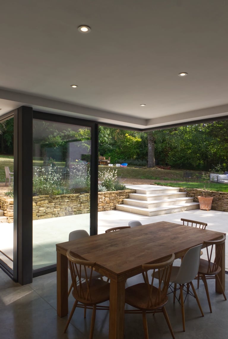Interior dining space with indoor outdoor living. Cantilevered corner sliding doors.