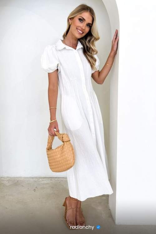 a woman in a white dress and straw hat