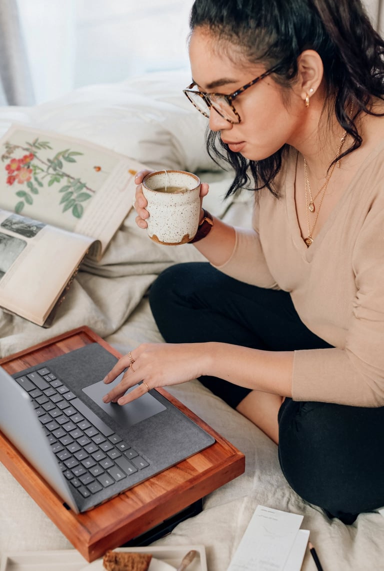 woman drinking tea in front of computer