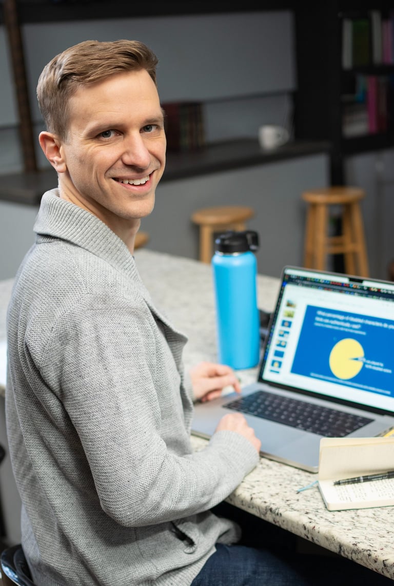 Remy sitting in a coffee shop working at their laptop, but turned to smile at you