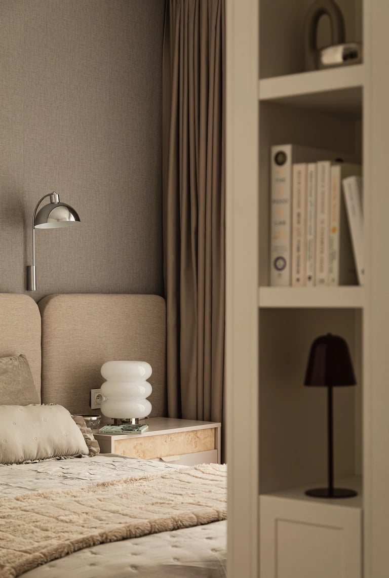 Sesja zdjęciowa sypialni: szklana lampa nocna Bubble, beżowe panele ścienne i regał na książki.