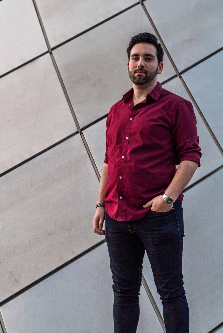 Wide picture of Manuel Tirado, wearing a red shirt and black pants.