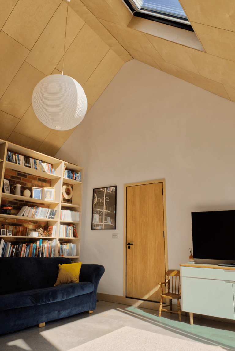 Modern interior living space. Interesting vaulted plywood ceiling and matching joinery.