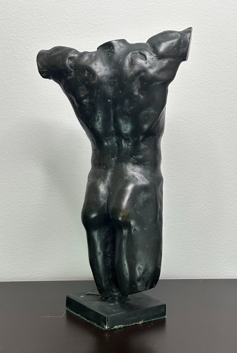 a sculpture of a man's torso from the rear