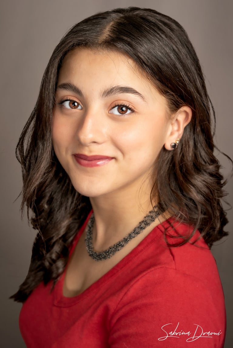 a girl in a red shirt and necklaces