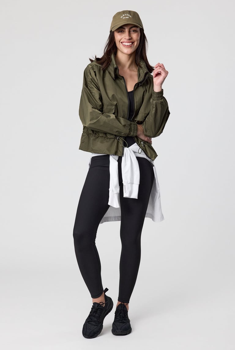 Fashion e-commerce photography - a woman in a green jacket and black leggings