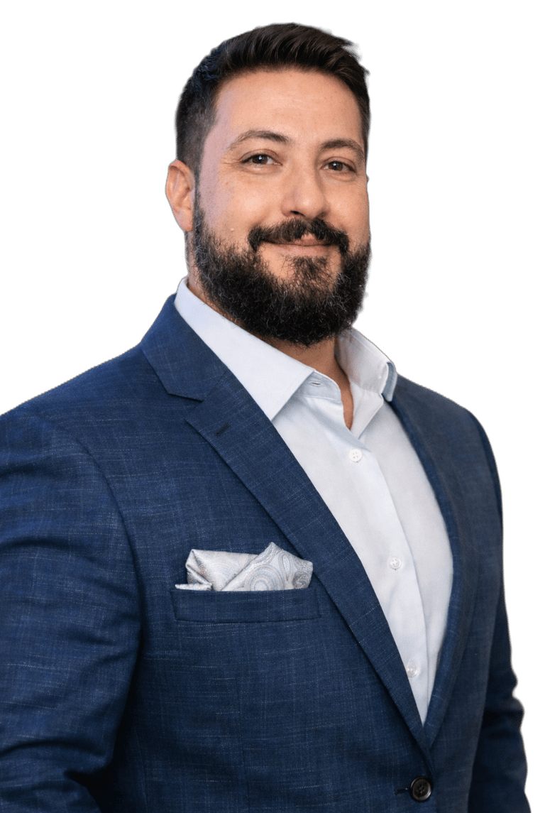 Professional headshot of a bearded man wearing a navy blue blazer and light blue dress shirt.