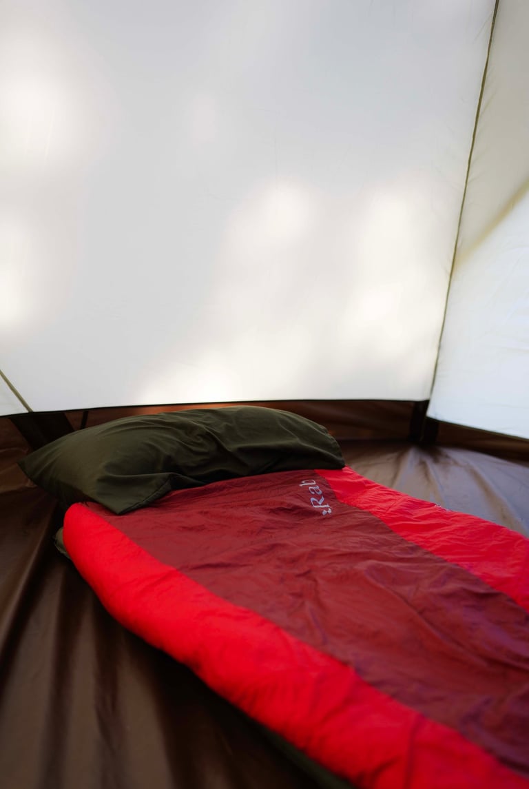 A sleeping bag in a tent with a pillow
