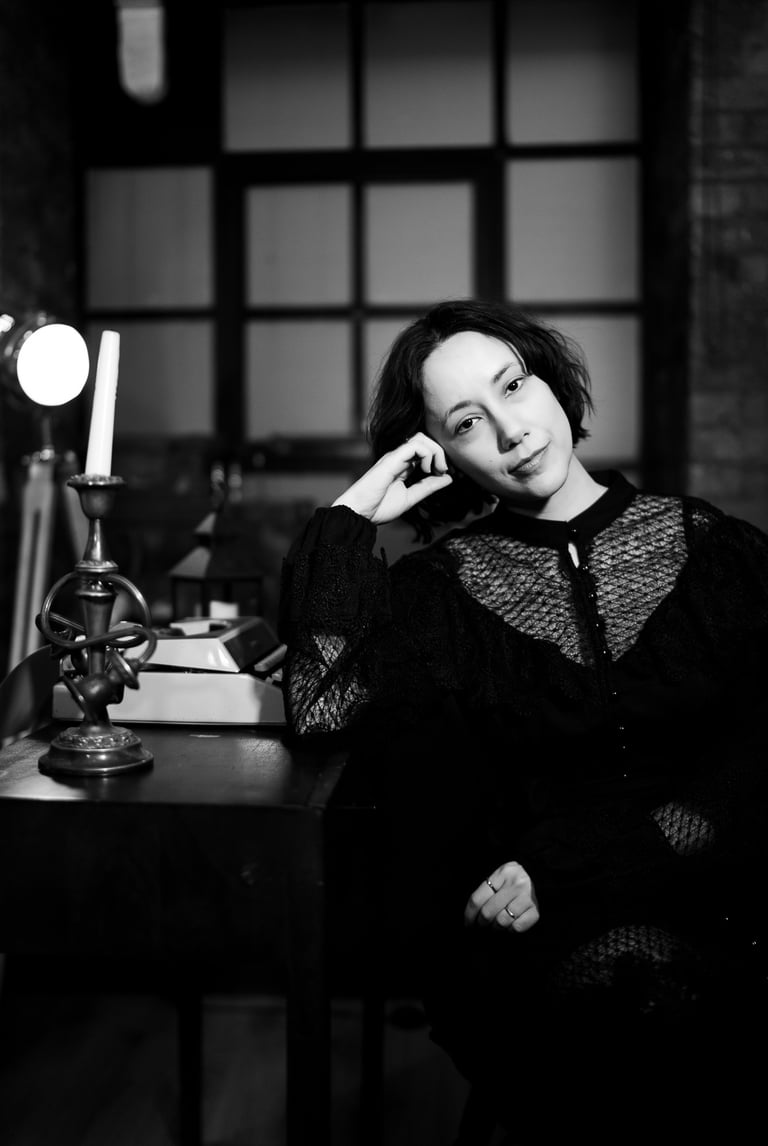 B&W picture of Maria sitting down next to a desk
