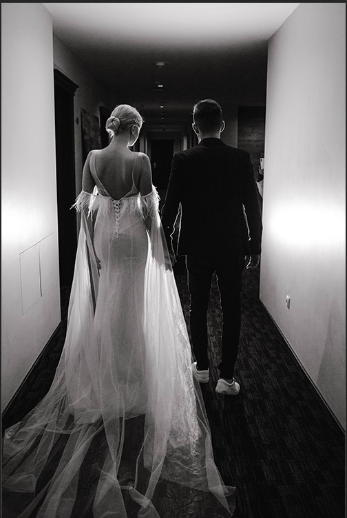a bride and groom walking down a hallway