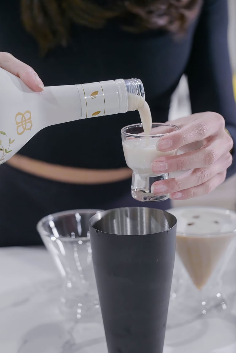 a woman pouring a drink into a glass
