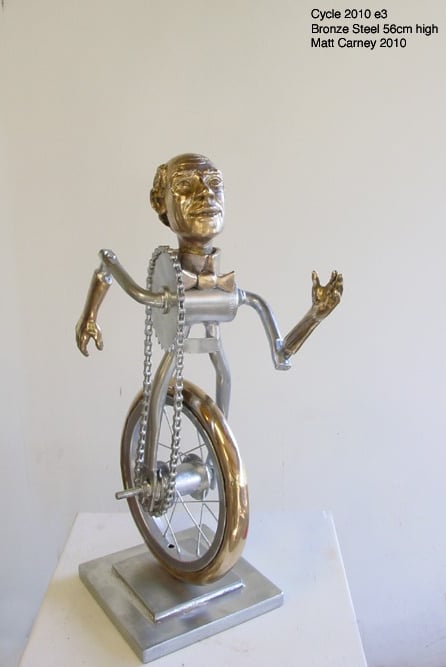 a metal sculpture of a man as a bicycle