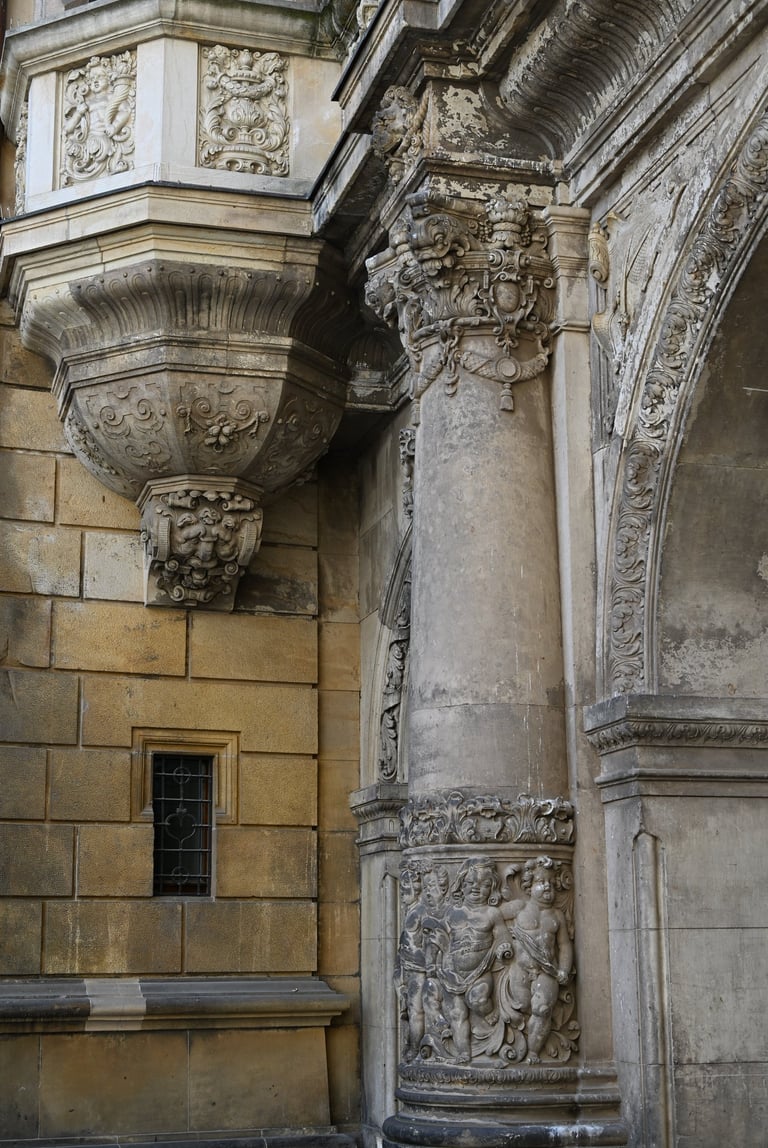 Ornate Baroque stone architecture featuring intricate carvings, columns, and a decorative balcony facade.