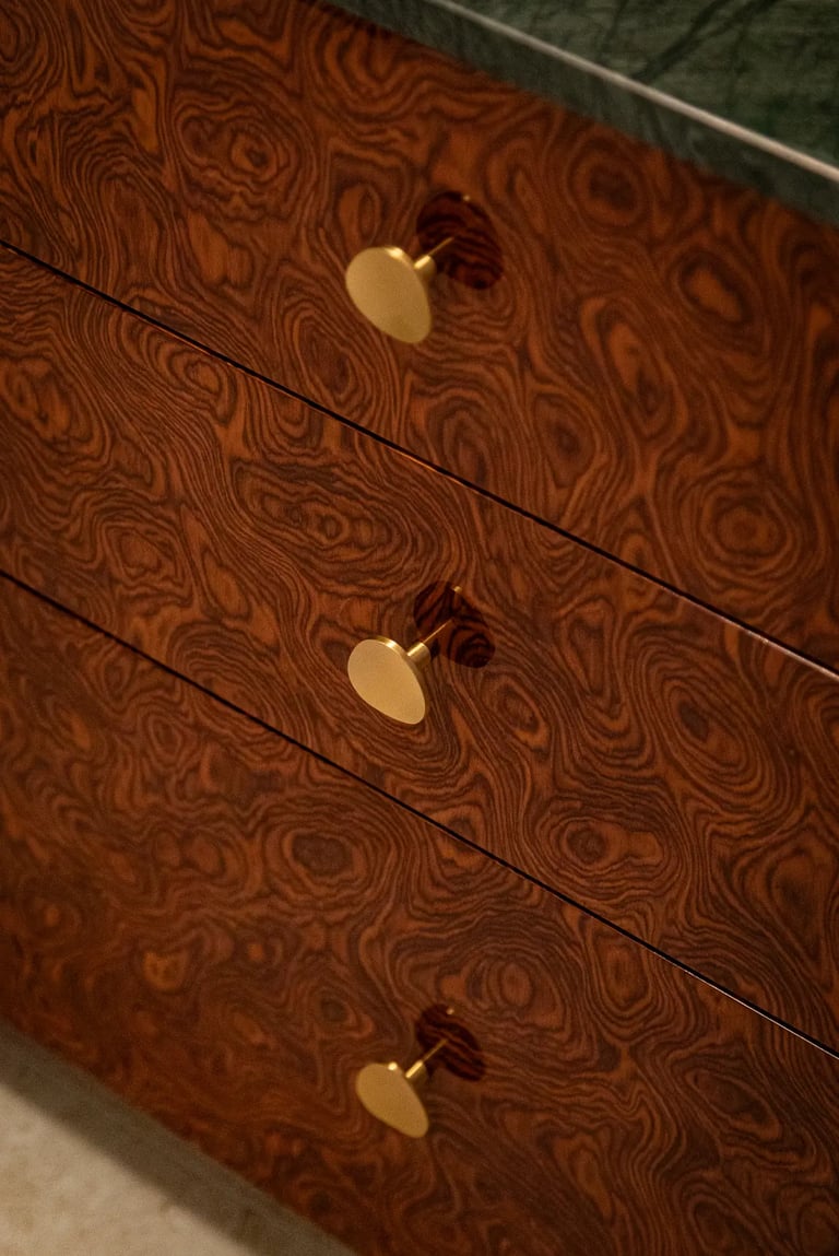 Fotografia mebli: detale forniru czeczota i złote gałki.