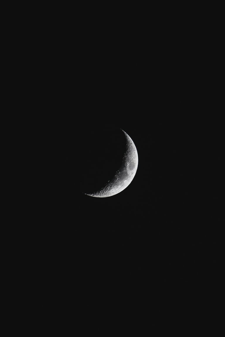 a crescent moon in the dark sky