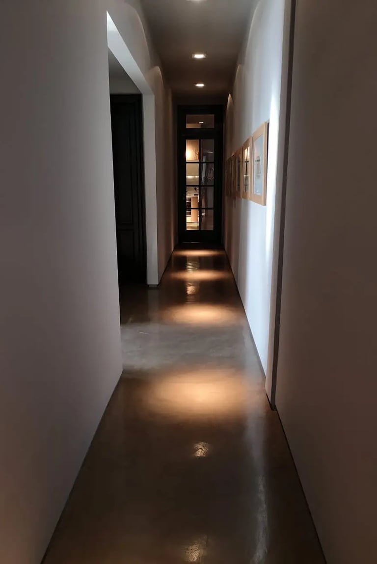 Pasillo ambientado con iluminación puntual, intimista y moderno.